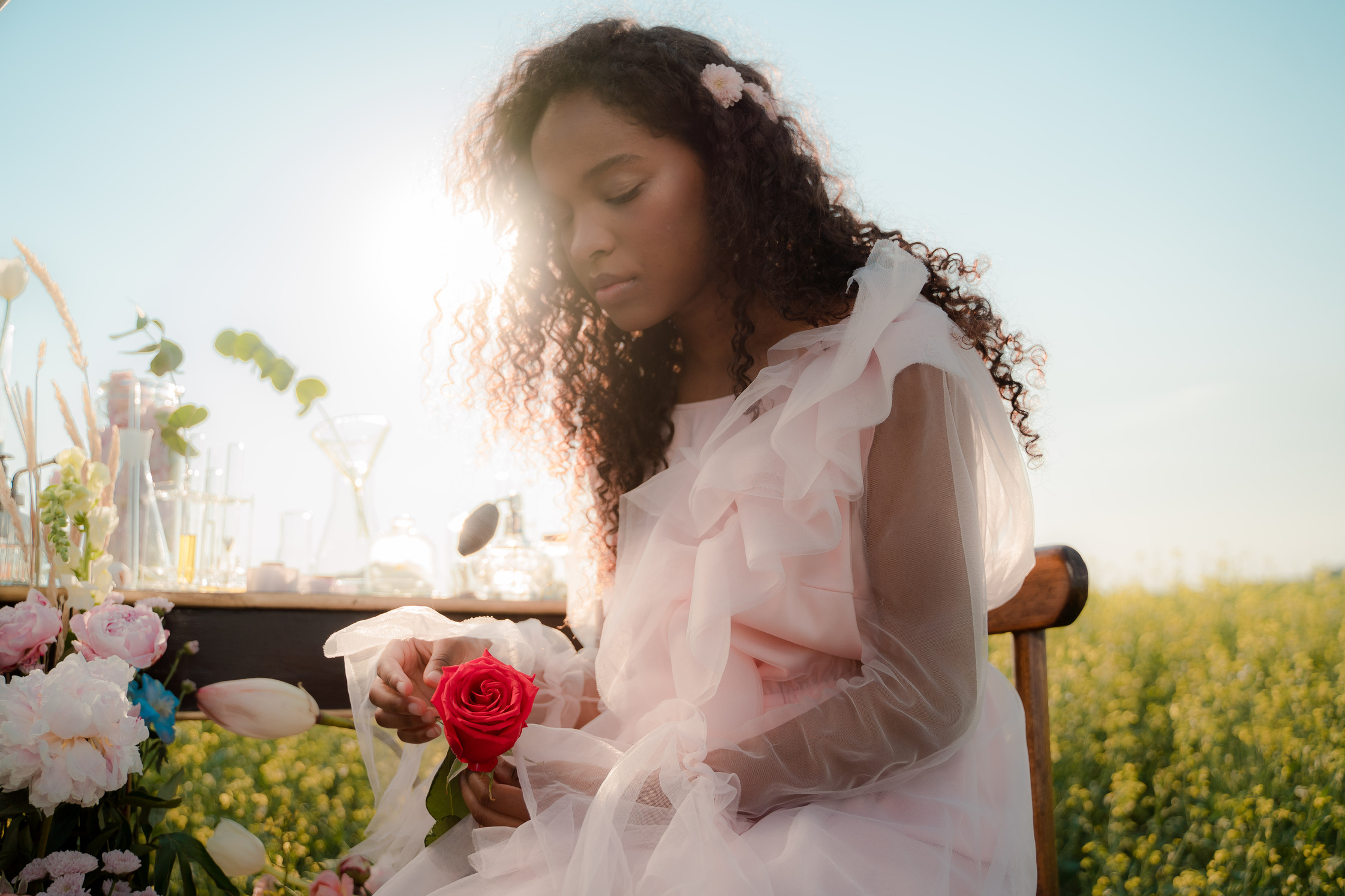 Curly Haired Woman in Dress Holding Rose